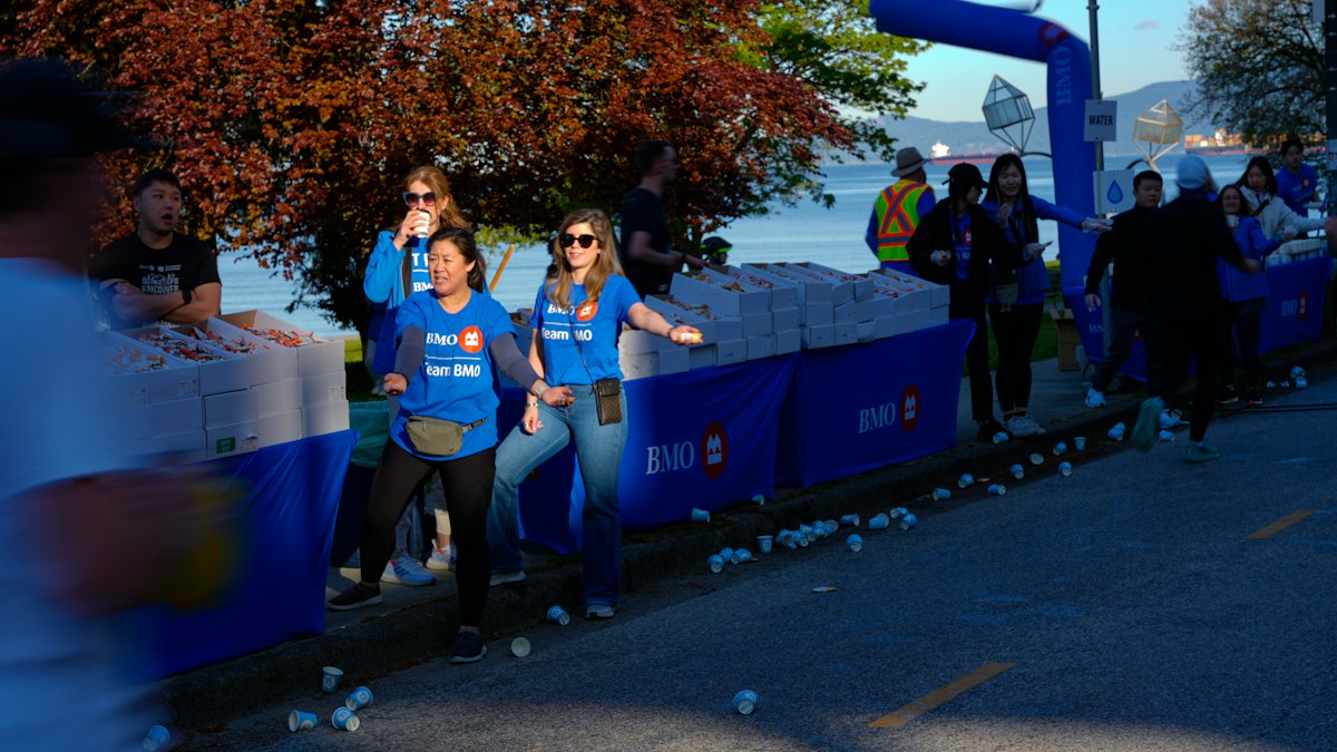 Volunteers in matching shirts cheering runners along a race route